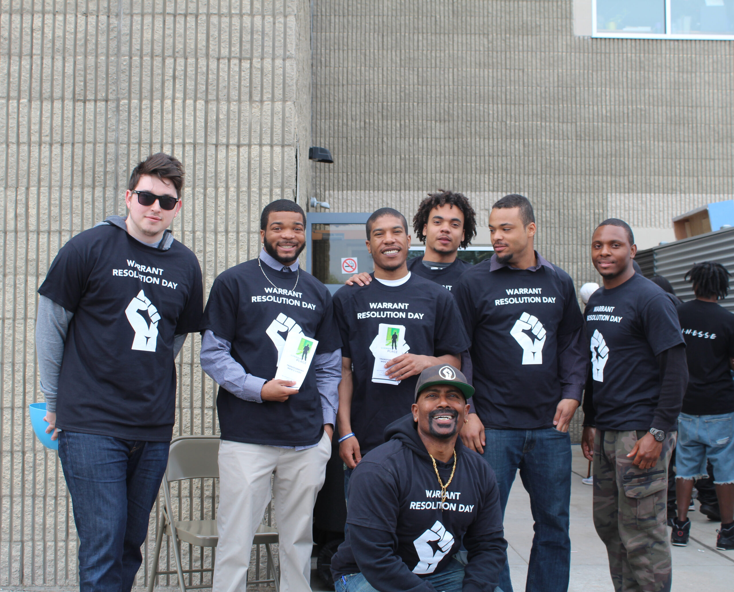 group of people with warrant forgiveness day t-shirts