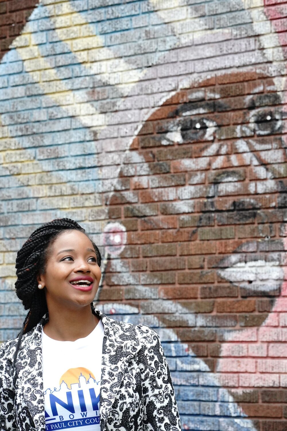 Photo of Anika Bowie standing in front of a mural.