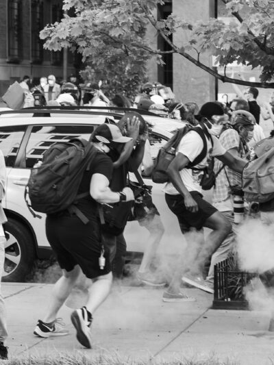 Black Lives Matter Protestors run as tear gas is dispensed into the crowd.