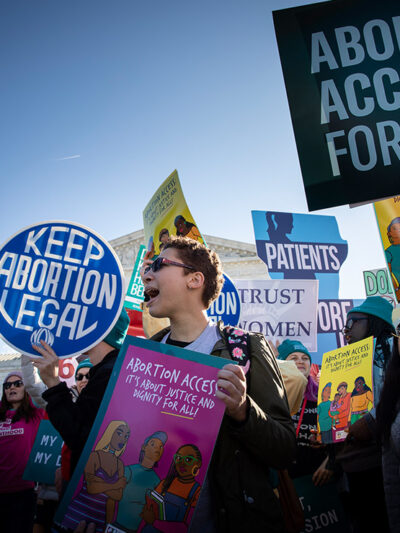 Abortion activists hold signs at rally that read" Keep Abortion Legal" and "Abortion Access for All."