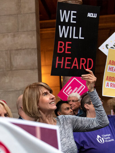 Supporters of abortion-rights attend a reproductive freedom rally at state capitol in Nebraska, holding ACLU signs that read "We will be heard" and "abortion is healthcare."