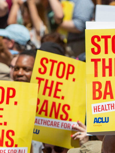 Protestors holding signs calling for the end of abortion bans.