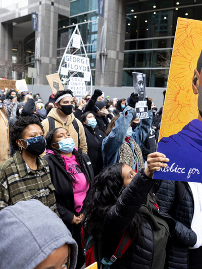 Demonstrators carry signs demanding justice for George Floyd.