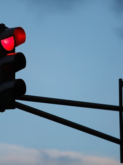 Traffic light with red light against the evening sky. Shallow depth of field.