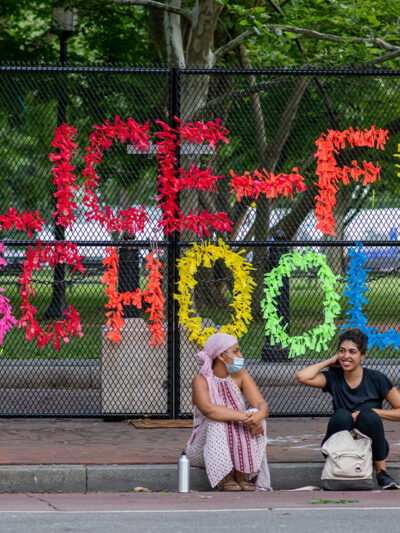 A sign made out of confetti that reads "Police Free Schools" on a gate during a Black Lives Matter protest.