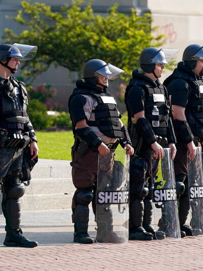 Police in riot gear stand outside the Kenosha County Court House