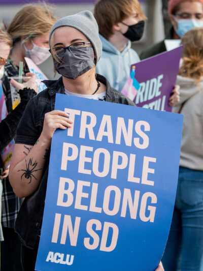 Protestor holds sign reading “Trans People Belong In SD” during trans rights rally.