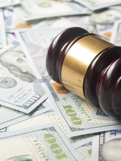 A judges' gavel on a U.S. dollar cash background, top view, close-up.