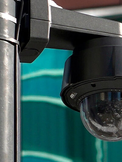A close-up of a black surveillance camera on a black pole in Chicago.