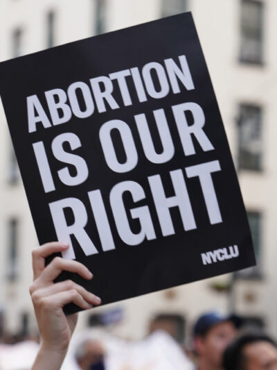 A person holding up a sign saying "Abortion is Our Right."