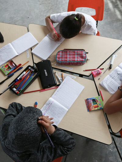 Migrant children working inside a classroom.