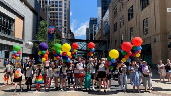 Crowd of ACLU supporters holding up rainbow balloons at Twin Cities Pride
