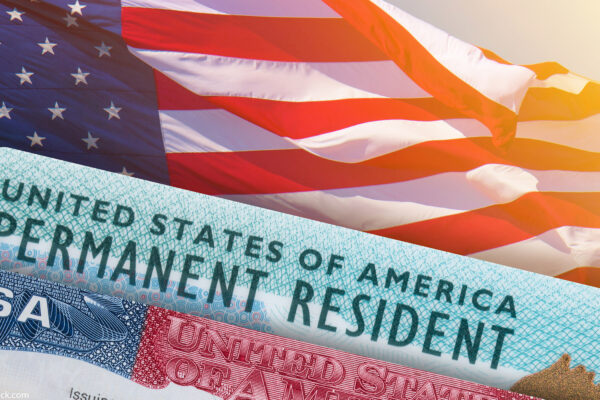 Visa and permanent resident card on top of an american flag
