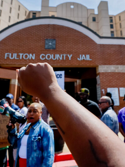Protester with raised fist in the air at Fulton County Jail after the death of Lashawn Thompson.