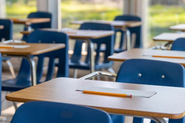 Photo of student desks with blue chairs in a row.