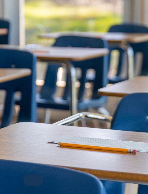 Photo of student desks with blue chairs in a row.