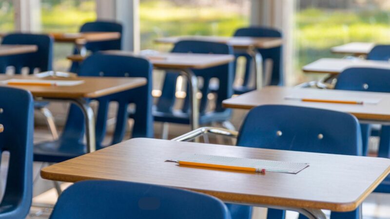 Photo of student desks with blue chairs in a row.