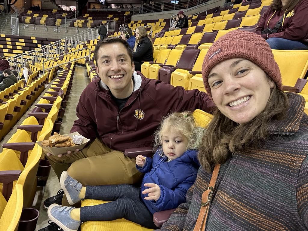 Photo of Luis Islas, his wife and their daughter at a UMD hockey game