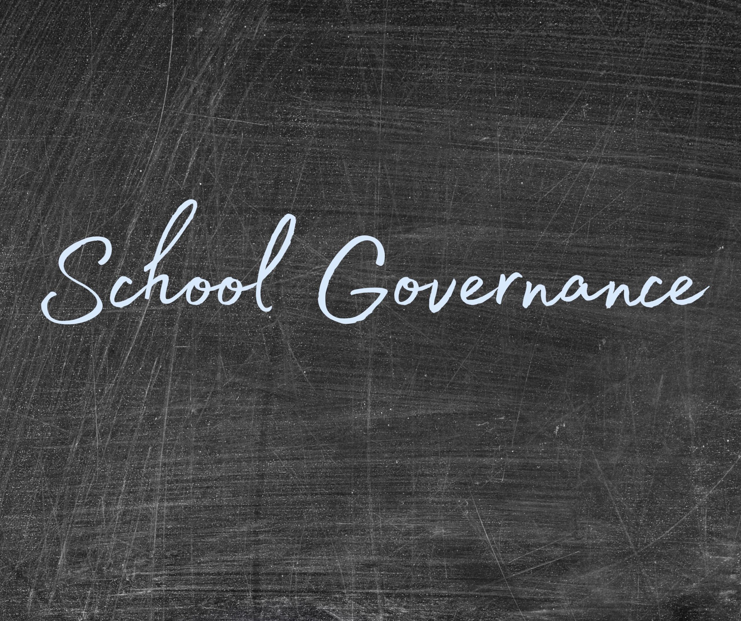 Photo of a blackboard with the words "school governance" written in blue chalk.