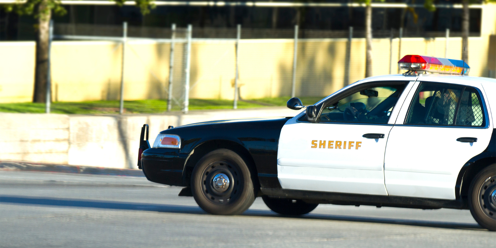 A sheriff's vehicle in front of a park landscape
