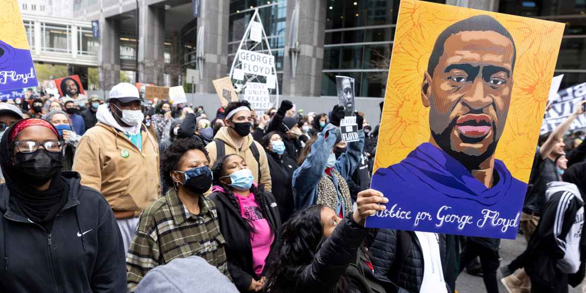 Protestors holding up a portrait of George Floyd