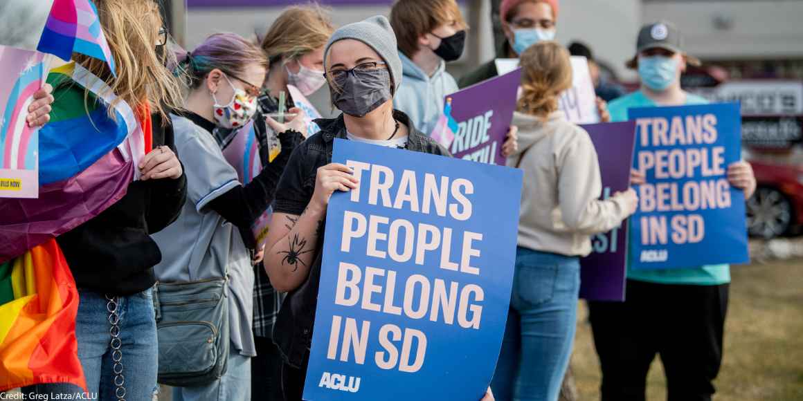 Protestor holds sign reading “Trans People Belong In SD” during trans rights rally.