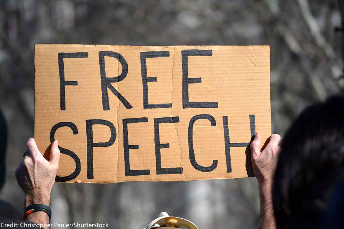 A sign reading FREE SPEECH is held aloft by person protesting immigration laws banning some Muslims at Battery Park in Manhattan in 2017 in New York City