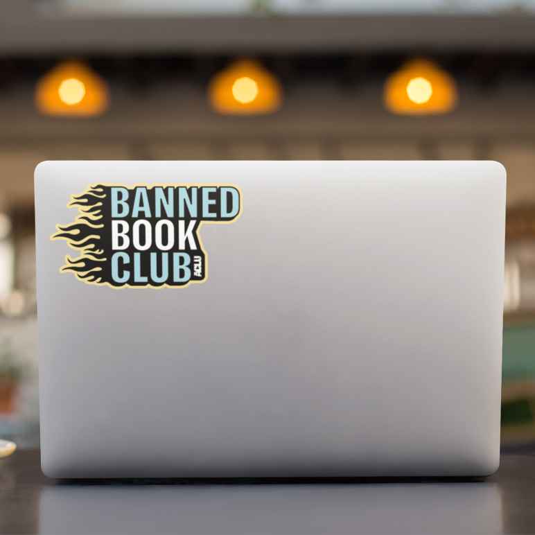 grey laptop with sticker that says "banned book club" 