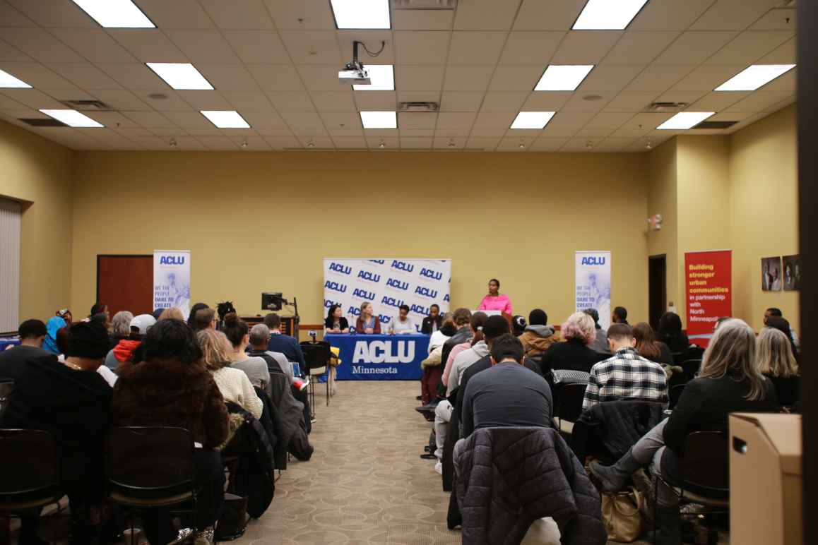 Minneapolis NAACP President Leslie Redmond speaks at a town hall event, where ACLU staff also participated. View is from the back of the room, towards the panelists' table.