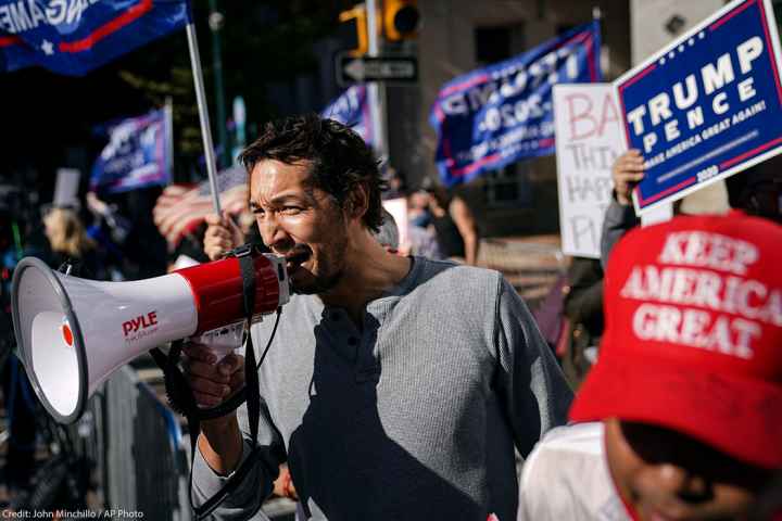 A man uses a bullhorn as he demonstrates with supporters of Donald Trump outside the Pennsylvania Convention Center