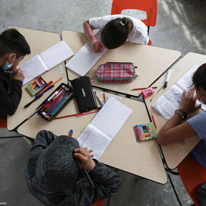 Migrant children working inside a classroom.
