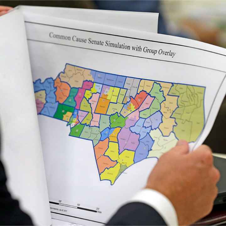 An elected official reviews a map of North Carolina districts at select committee meeting on redistricting.