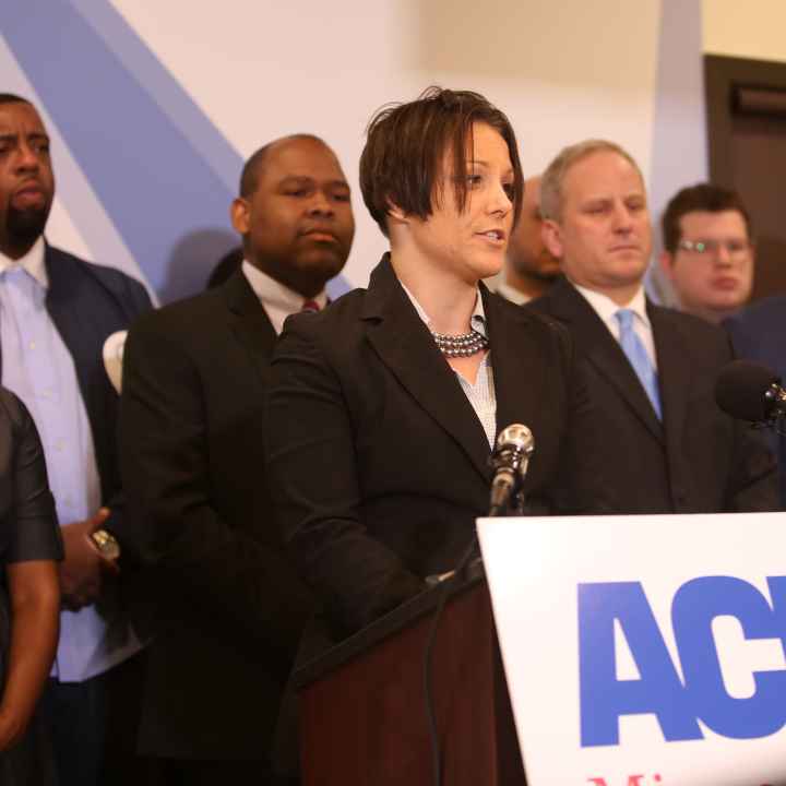 Jen speaks at a podium in the ACLU-MN office, during the Let People Vote press conference
