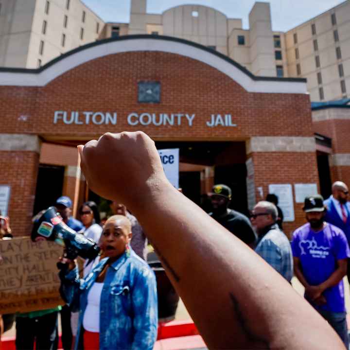 Protester with raised fist in the air at Fulton County Jail after the death of Lashawn Thompson.