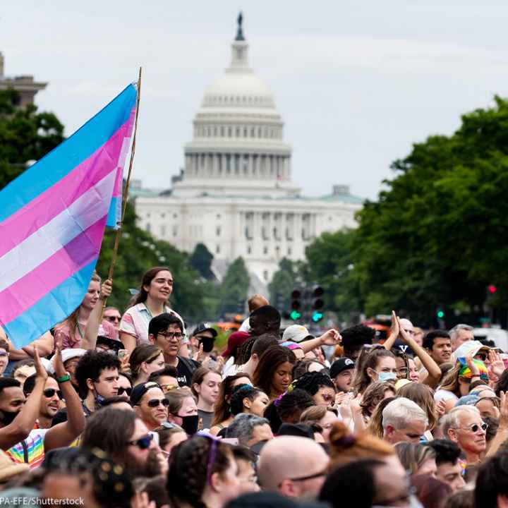 Trans flag flown at Capital Pride parade in Washington, DC, with the US Capitol in the background.